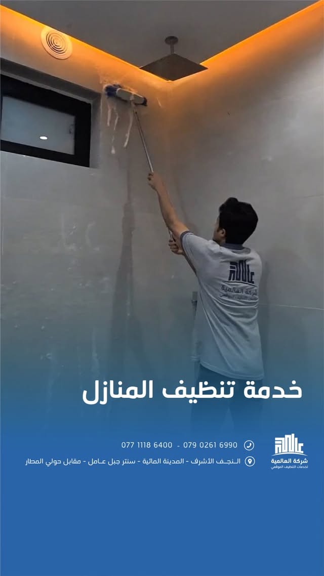 عامل ينظف جدران حمام بفرشاة طويلة